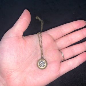Long gold necklace with small multiple diamond pendant.